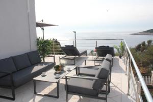 a balcony with chairs and tables and a view of the ocean at Hvar Dream View Penthouse with Hot Tub in Hvar
