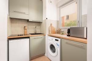 a kitchen with a washing machine and a sink at Oasis Cachée - Jacuzzi et cinéma in Toulouse +8 photos