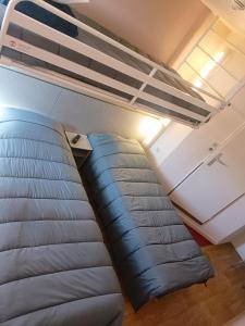 a couch in a room with a bunk bed at CLASSIC HÔTEL Reims Est - Taissy in Reims