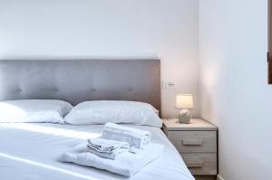 Un dormitorio con una cama blanca con toallas. en BluesHouse Carracci, en Bolonia