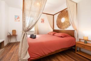 a bedroom with a bed with orange sheets at Oasis Cachée - Jacuzzi et cinéma in Toulouse