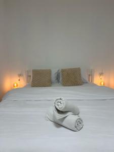 a white bed with towels on it with two pillows at Ocean view - מול הים in Nahariyya
