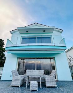 a blue building with a table and chairs in front of it at Villa Eva in Mazotos +27 photos