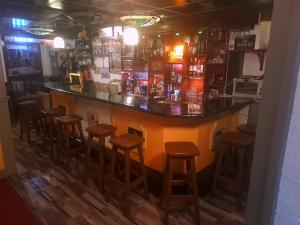 a bar with wooden stools in a room at Slotje in Egmond aan den Hoef +4 photos
