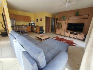 a living room with a large blue couch and a kitchen at Am Siegelbächle Berg blickt in Siegelau +36 photos