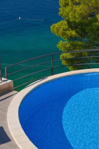 uma grande piscina azul junto à água em Villa Paulina em Brela