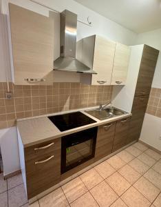 kuchnia z drewnianymi szafkami i piekarnikiem w obiekcie Apartment Pirun w Bašce