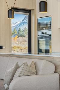 a living room with a couch and a large window at Lyngvær Aurora Lodge - Jacuzzi - No 03 in Lyngværet +22 photos