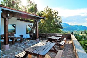 un grupo de mesas de picnic de madera en un patio en Casa Rural Haitzetxea, en Zugarramurdi
