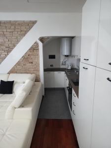 デセンツァーノ・デル・ガルダにあるAPPARTAMENTO LAKE GARDA ibiscus di Franciaの白いソファとキッチンのあるリビングルーム