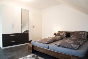 FriedenweilerにあるFerienwohnung am Waldrandのベッドルーム1室(ベッド1台、ドレッサー付)