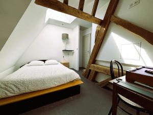 una camera mansardata con letto e scrivania di Résidence du Palais a Bourges
