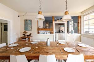 a dining room with a wooden table and white chairs at Stilhaus 1730 in Königsbach Stein