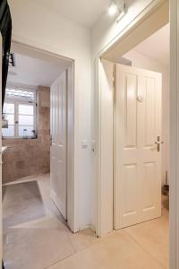 a hallway with a white door and a bathroom at Stilhaus 1730 in Königsbach Stein +47 photos