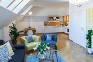 プラハにあるRomantic Balcony Apartment in Old Townのリビングルーム(ソファ、椅子付)、キッチンが備わります。