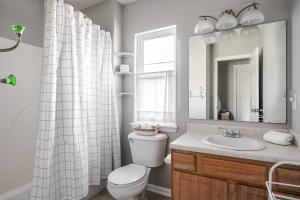 a bathroom with a toilet and a sink and a mirror at Cozy Downtown Escape Hot tub and Modern Touches in Indianapolis
