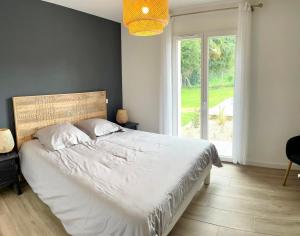 a bedroom with a large bed and a large window at Le chant du Gave- Maison neuve lumineuse avec piscine- Rivière en contrebas du jardin in Sauveterre +34 photos