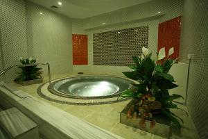 a large bathroom with a tub with flowers in it at Latanya Palm Hotel Antalya in Antalya