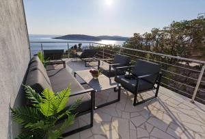 a patio with a couch and chairs on a balcony at Hvar Dream View Penthouse with Hot Tub in Hvar