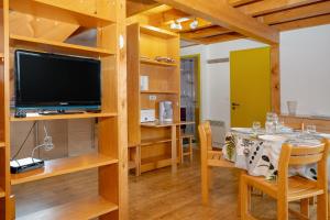 a dining room with a table and a tv at Chalet 228 - Village nordique in Les Déserts