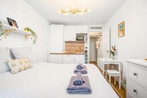 Un dormitorio con una cama blanca con toallas. en Beaurivage, en Menton