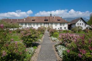 un giardino fiorito di fronte a un edificio bianco di Klosterherberge Solothurn Self Check-in a Solothurn