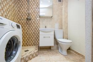 a bathroom with a toilet and a washing machine at Svencelės butas in Svencelė