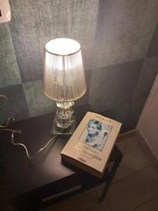 a table with a lamp and a book on it at La Petite Maison in Naples