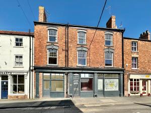Un gran edificio de ladrillo en la esquina de una calle. en The Bradley, en Market Weighton