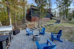 a group of blue chairs in front of a cabin at The Covery the Wren House a luxury African tent retreat on stocked bass pond in Hot Springs