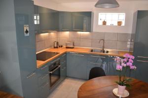 a kitchen with blue cabinets and a wooden table at Bleautiful "Aliénor" Charmant appartement avec terrasse in Fontainebleau