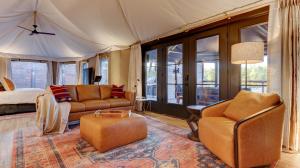 a living room with a bed and a couch and chairs at The Covery the Wren House a luxury African tent retreat on stocked bass pond in Hot Springs