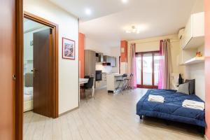 a bedroom with a bed and a living room at Il Vascello by ACS HOLIDAYS in Lido di Ostia
