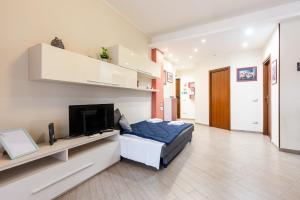 a bedroom with a bed and a flat screen tv at Il Vascello by ACS HOLIDAYS in Lido di Ostia