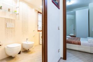 a bathroom with a toilet and a sink and a bed at Il Vascello by ACS HOLIDAYS in Lido di Ostia +17 photos