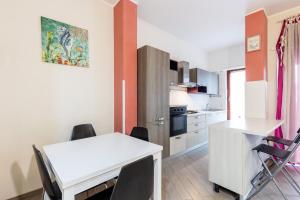a kitchen with a white table and chairs in a room at Il Vascello by ACS HOLIDAYS in Lido di Ostia