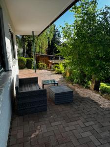 a patio with two chairs and a table and an umbrella at Ferienwohnung Wiesental in Kohlstetten