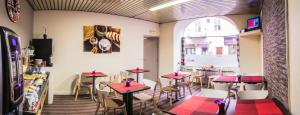 a restaurant with tables and chairs in a room at Théâtre Hôtel Chambéry in Chambéry