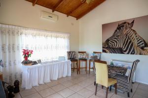 a living room with a table and a picture of zebras at Whalesong Guest House in St Lucia