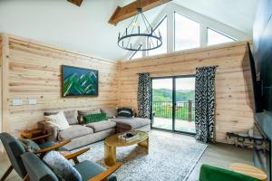 ein Wohnzimmer mit einer Couch und einem Kronleuchter in der Unterkunft Bearly Haus -Views, Hot Tub, Pool & Xbox! in Pigeon Forge