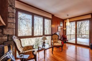 a living room with large windows and a stone wall at Villa Panoramica Indipendente in Sestola +71 photos