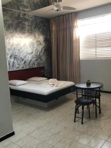 a room with a bed and a table in it at Hotel Londres - taguatinga in Brasilia