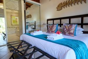 a bedroom with a large bed with towels on it at Whalesong Guest House in St Lucia +49 photos
