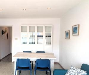 ロザスにあるGlobal Immo 3355 Solanaのダイニングルーム(テーブル、青い椅子付)