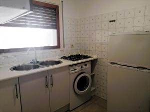 ロザスにあるGlobal Immo 3355 Solanaのシンクと洗濯機付きのキッチン +6枚の写真