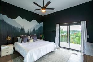 ein Schlafzimmer mit einem Bett und einem großen Fenster in der Unterkunft Bearly Haus -Views, Hot Tub, Pool & Xbox! in Pigeon Forge + 59 Fotos