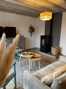 Una sala de estar con un sofá, una mesa y un televisor. en Maison de Village, en Lacrouzette