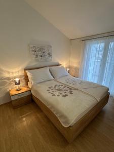 sypialnia z dużym łóżkiem i oknem w obiekcie Apartment Pirun w Bašce