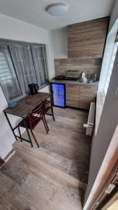 a small kitchen with a wooden table and a counter at Apartament 3 Closca in Floreşti