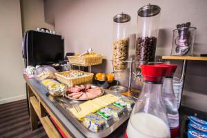 a counter with food and a bottle of milk at Théâtre Hôtel Chambéry in Chambéry +30 photos